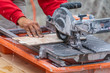 © Andy Dean - Worker Using Wet Tile Saw to Cut Wall Tile At Construction Site
