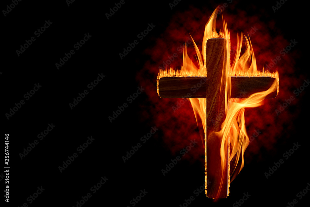 Cross burning or lighting concept theme with wooden crucifix engulfed in fiery flames isolated on black background with copy space. It was used as a declaration of war, to protest, to intimidate, etc - obrazy, fototapety, plakaty 