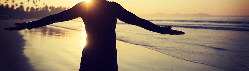 Happy Free Woman at Sunrise on the Beach