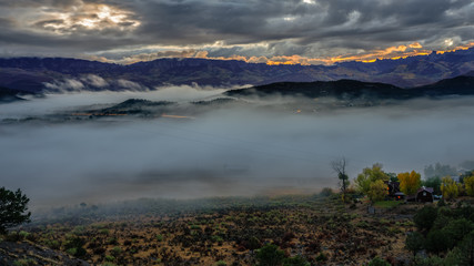 Wall Mural - Rising sun outlining the ridge with autumn mist covering Ridgway Colorado