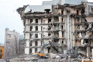 Demolition and destruction of a building using excavator. Destroyers equipment.