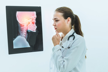 Female doctor working with x ray film of patient head and diagnose skull injury. Medical and healthcare staff service concept.