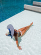 © Netfalls - Woman relaxing in swimming pool at spa resort. r
