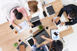 © InfiniteFlow - Top view of businessman executive in group meeting with other businessmen and businesswomen in modern office with laptop computer, coffee and document on table. People corporate business team concept.