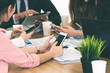 © InfiniteFlow - Businessman executive in group meeting discussion with other businessmen and businesswomen in modern office with coffee cups and documents on table. People corporate business working team concept.