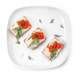 Plate with tasty canapes on white background