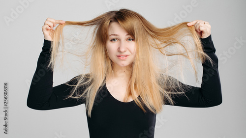 Pretty Blonde Haired Woman Wearing In Black Sweater Holding Messy