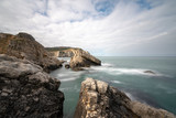 Fototapeta  - Black sea and the beach with rocks and waves with cloudy sky, 