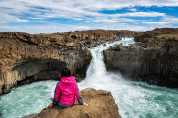 Wall Mural - Traveler hiking in Icelandic summer landscape at the Aldeyjarfoss waterfall in north Iceland. The waterfall is situated in the northern part of the Sprengisandur Road within the Highlands of Iceland.