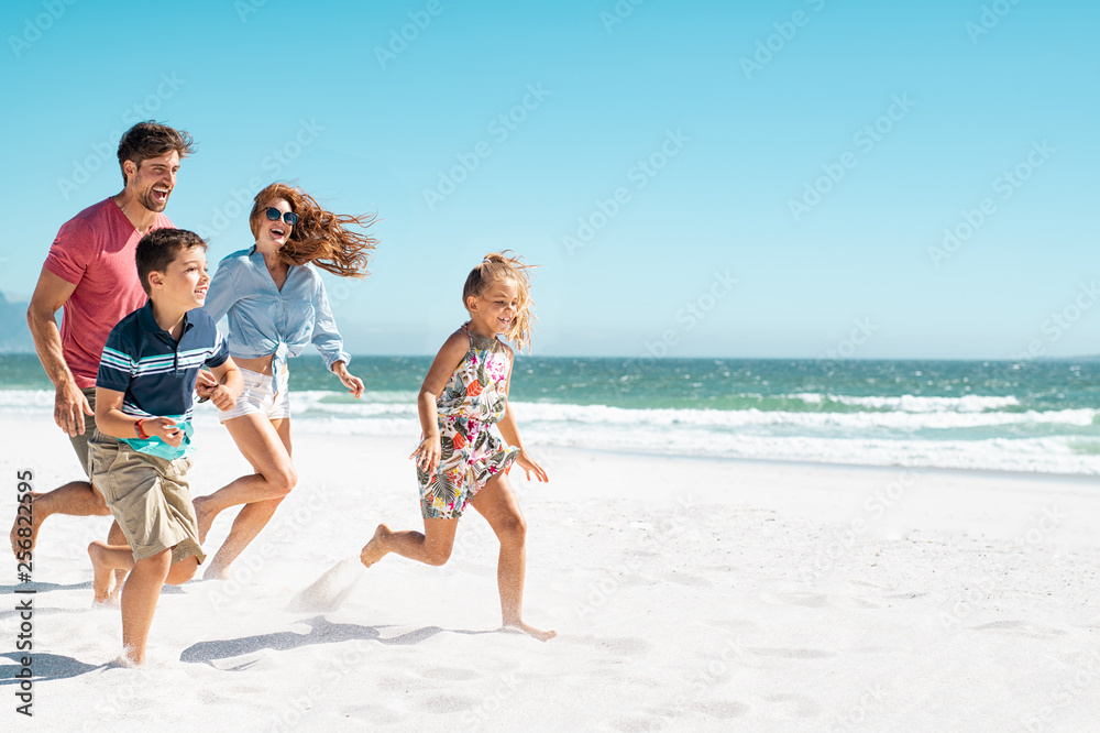 Happy family running on beach - obrazy, fototapety, plakaty 