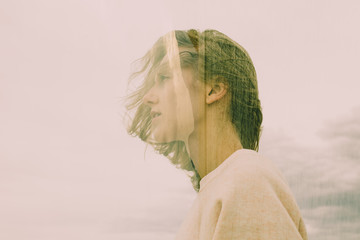 Pink multi-exposure portrait, profile of girl with messy hair, cloudy sky, seashore, wind, connection with nature