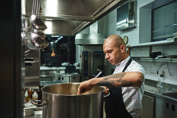 Wall Mural - Step by step. Cooking famous soup by professional male chef in a restaurant kitchen