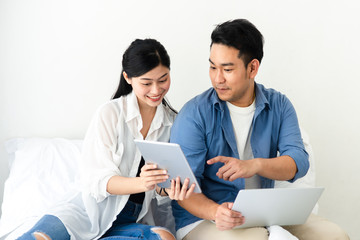 Happy Asian couple using laptop at home, lifestyle concept.