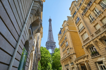 Wall Mural - Eiffel Tower and typical street with ancient buildings in Paris in a sunny summer day, clear blue sky