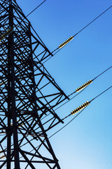 high voltage electricity pylon and transmission power line on the blue sky and white clouds on the b