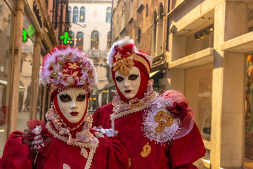 Italy, Venice, 2019, carnival, people with beautiful masks walk around Piazza San Marco, in the streets and canals of the city, posing for photographers and tourists, with colorful clothes.