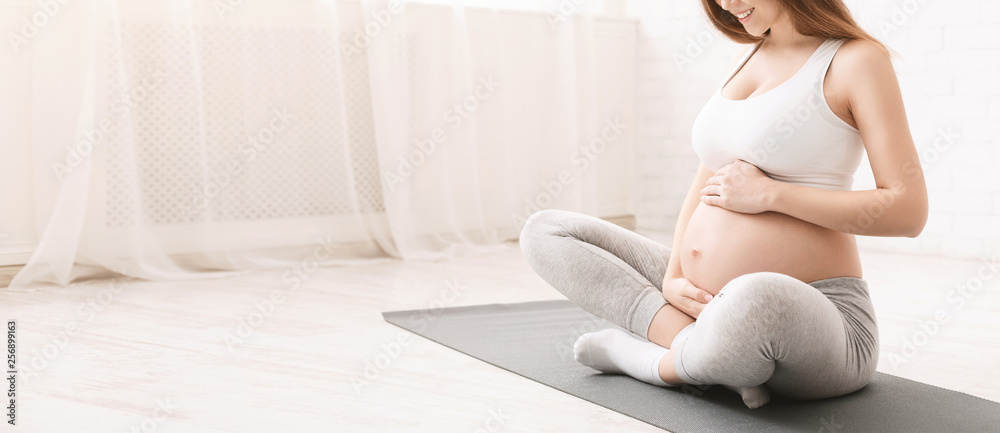 Active pregnant woman sitting on floor after doing sports - obrazy, fototapety, plakaty 