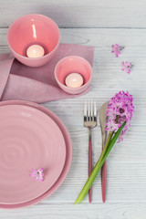 Wall Mural - Pink rustic table setting with purple hyacinth flower, candles and linen napkin on white wooden table