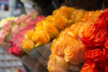 A warm gradient of rose bouquets at the grocery