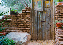 Weathered Wooden Doors On An Abandoned Adobe Structure Showing Several Remaining Walls