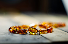 Amber Necklace On A Wooden Surface In A Zone Of Inertia