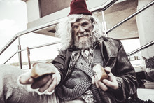 Caucasian Almsman Sitting And Eating Bun Which He Finding On The Street.