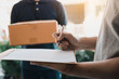 © wutzkoh - Close up of hand recipient of the package is receiving goods from the delivery staff at the front of the house.