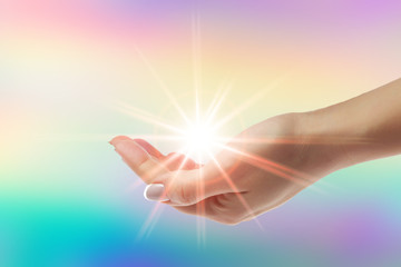 Wall Mural - Healing hands with bright sunburst on rainbow background