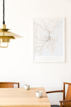 Stylish And Modern Dining Room Interior With Mock Up Poster Map, Sharing Table Design Chairs, Gold Pedant Lamp And Cups Of Coffee. White Walls, Wooden Parquet. Minimalistic And Eclectic Decor.