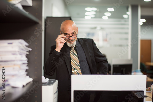 Fotografía Senior bald man working in office with black suit