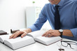 © New Africa - Notary studying law books at table in office, closeup
