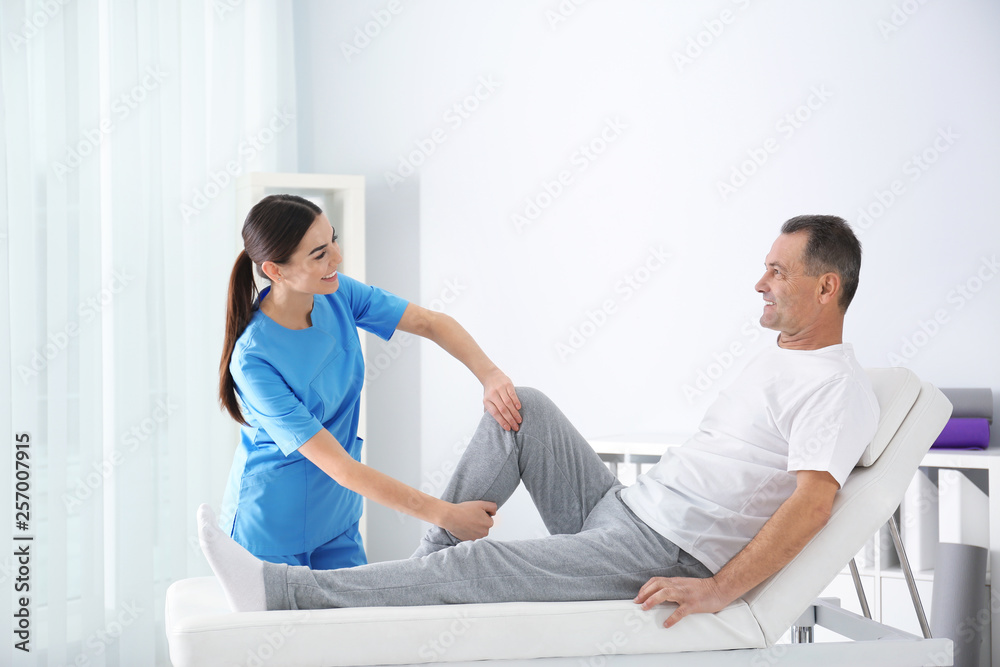 Doctor working with patient in hospital. Rehabilitation physiotherapy