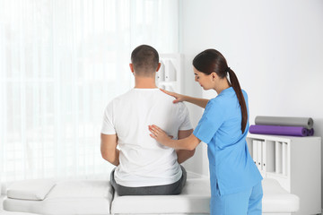 Wall Mural - Doctor working with patient in hospital. Rehabilitation massage