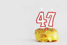 Forty Seven Years Anniversary. Birthday Cupcake With White Burning Candles With Red Border In The Form Of Number Forty Seven. Light Gray Background With Copy Space