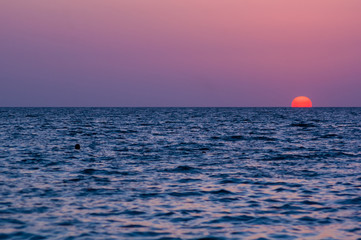 Wall Mural - Amazing sea sunset on the pebble beach, the sun, waves, clouds