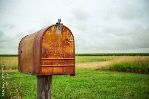 Fotografía An old rusty mailbox in a field.