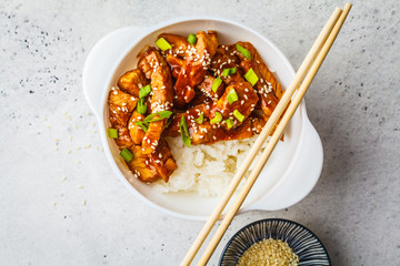 Wall Mural - Teriyaki chicken with rice, sesame and green onions in white bowl.