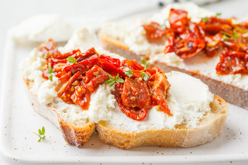 Wall Mural - Ricotta and sun dried tomatoes sandwiches on white board.