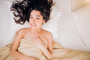 Wall Mural - Portrait pretty young girl on bed in modern apartment in the morning