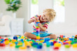 © famveldman - Child playing with toy blocks. Toys for kids.
