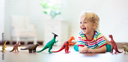 Cuadros en Lienzo Child playing with toy dinosaurs. Kids toys.