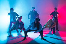 Group Of Diverse Young Hip-hop Dancers In Studio With Special Lighting Effects In Blue And Pink Colores