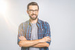 © denis_vermenko - Happy young man. Portrait of handsome young man in casual shirt keeping arms crossed and smiling while standing against grey background