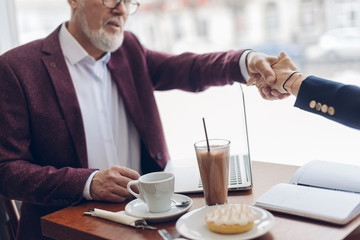 Wall Mural - old friends shaking hands.unexpected meeting in the cafe. close up cropped photo