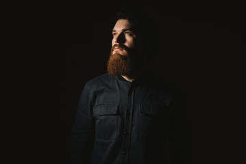 Close-up portrait of a handsome serious young man over dark background. Male beauty. Men's health.