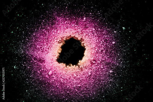 An explosion of pastel natural colored pigment powder on black background. Pu...