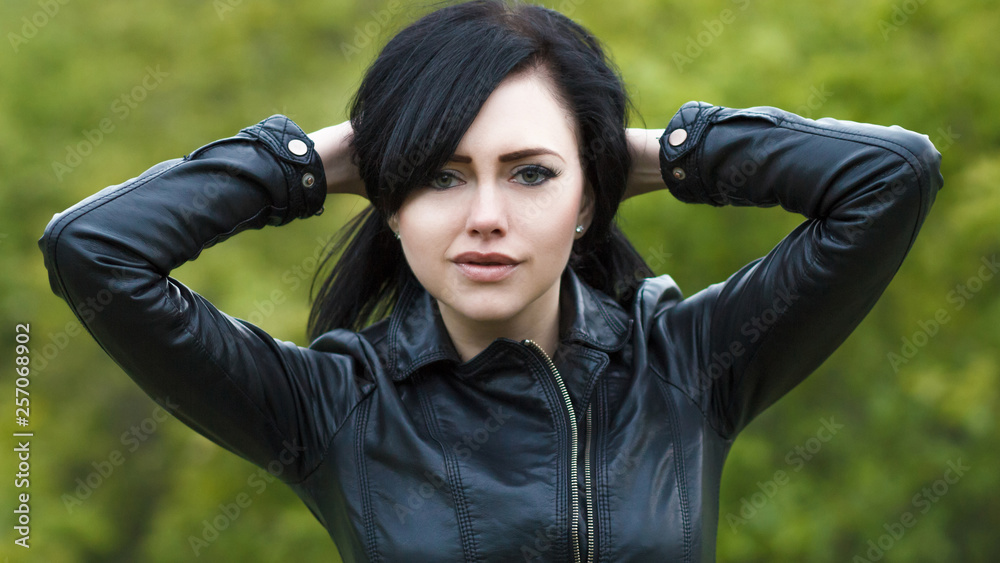 Portrait of a beautiful young girl in a leather jacket on the ...