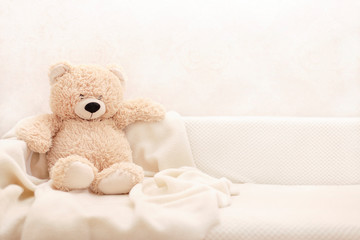 Children's toys - bears of brown and beige color are sitting on the sofa.