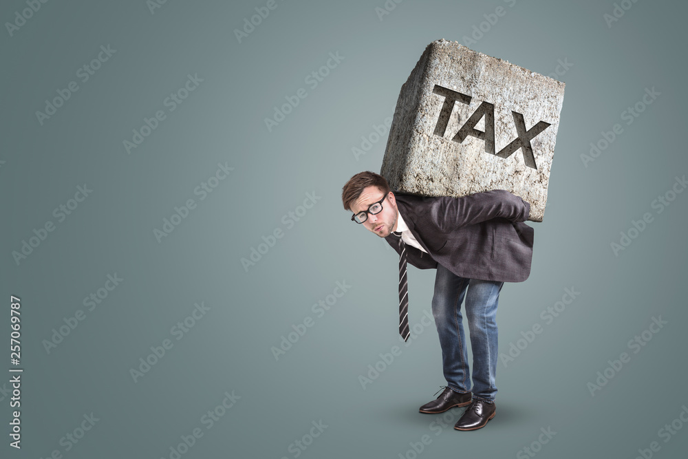 Businessman carrying a heavy stone with the word TAX on it - obrazy, fototapety, plakaty 