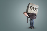 Fototapeta  - Businessman carrying a heavy stone with the word TAX on it